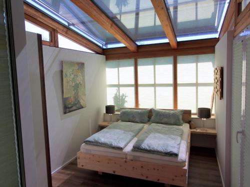 a bedroom with a bed in a room with windows at Ferienwohnung Zirbentraum in Breitbrunn am Chiemsee