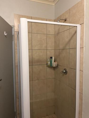 y baño con ducha y puerta de cristal. en Kay’s place, en Pretoria