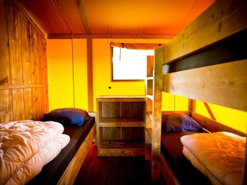מיטה או מיטות קומותיים בחדר ב-Recreatiepark Duinhoeve 8