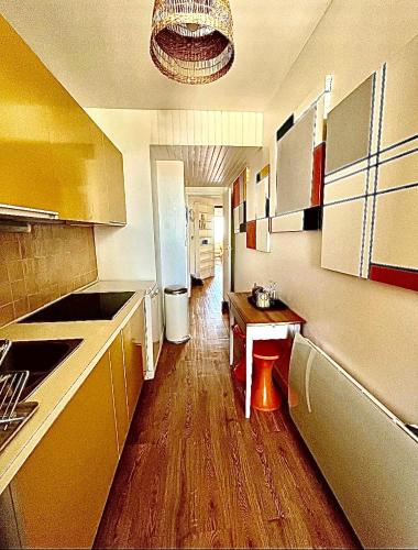 une petite cuisine avec un plancher en bois et des armoires dans l'établissement Petit nid d’Amour, terrasse, vue mer, 1ère ligne, à Palavas-les-Flots