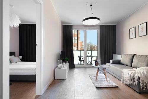 a living room with a couch and a bed at Elite Apartments Cityview Center in Gdańsk