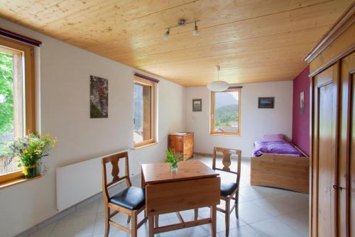 Zimmer mit einem Tisch und Stühlen sowie einem Schlafzimmer in der Unterkunft Les Soldanelles in Salvan