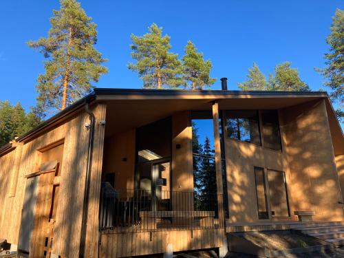 een hut in het bos met een grote glazen deur bij Suomalainen puinen huvila Havu Resort 17 henkilölle in Jyväskylä