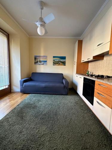 Apartment BelLenno في لينّو: غرفة معيشة مع أريكة زرقاء في مطبخ