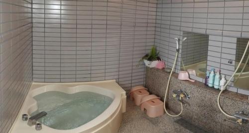 a bathroom with a tub with a shower and a toilet at Snowfall Meteor 飛雪流星 in Kaminoyama