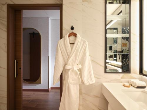 a robe hanging on a rack in a bathroom at INSPIRE Entertainment Resort in Incheon