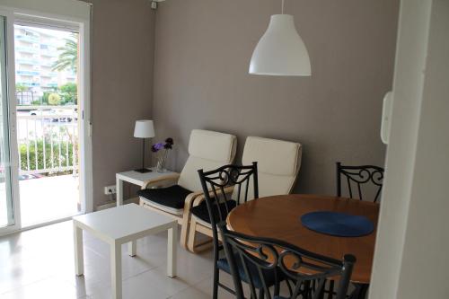 a living room with a dining room table and chairs at Agradable apartamento en Playa La Pineda (Tarragona) in La Pineda