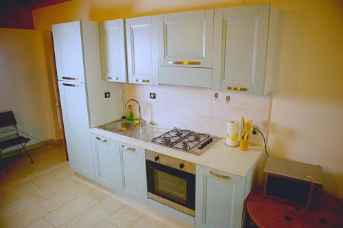una cucina con armadi bianchi e piano cottura di Orchidea del Garda Apartament a Peschiera del Garda