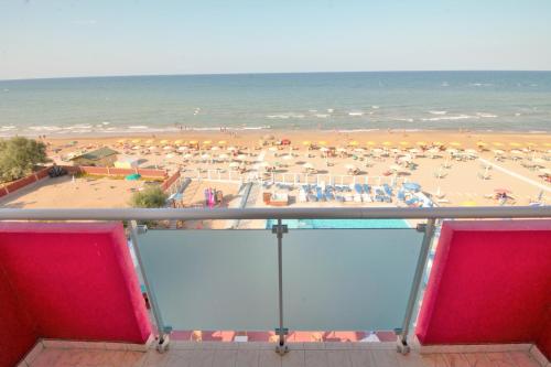 ファーノにあるHotel CasaDeiのビーチの景色を望む客室で、パラソルが備わります。