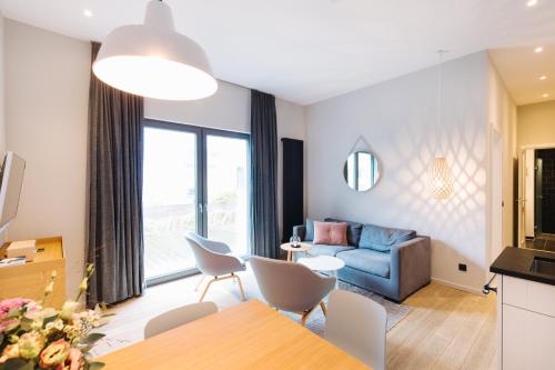 a living room with a blue couch and a table at Meerloft Norderney in Norderney