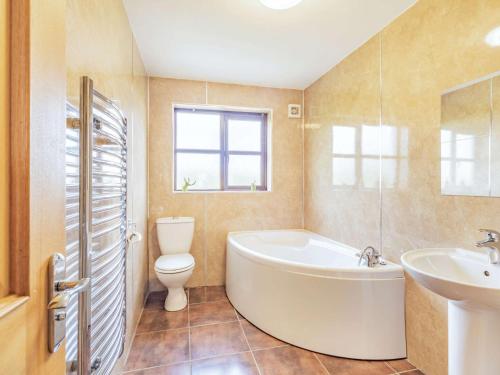 a bathroom with a tub and a toilet and a sink at 3 Bed in Berwick-upon-Tweed 87777 in Lamberton