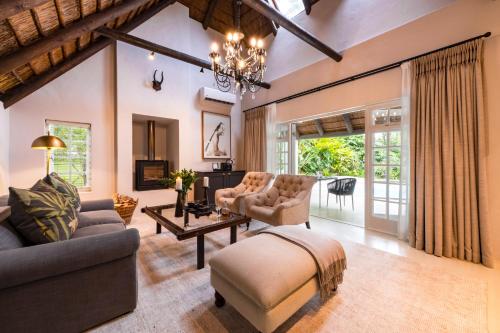 a living room with a couch and a table at Hunter's Country House in Plettenberg Bay