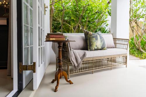 a couch on a porch with a table at Hunter's Country House in Plettenberg Bay