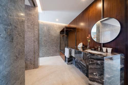 a bathroom with a sink and a mirror at Yeosu Calacatta Hotel & Resort in Yeosu