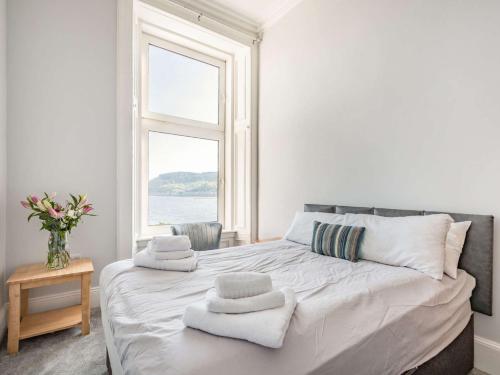 una camera bianca con un grande letto con asciugamani di 8 Bed in Dunoon 87881 a Dunoon