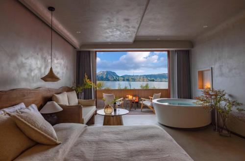 a living room with a tub and a view of the water at QiPan Holiday hotel Lugu Lake in Ninglang