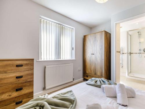 a bedroom with a bed and a dresser and a window at 5 Bed in Crich 88486 in Crich