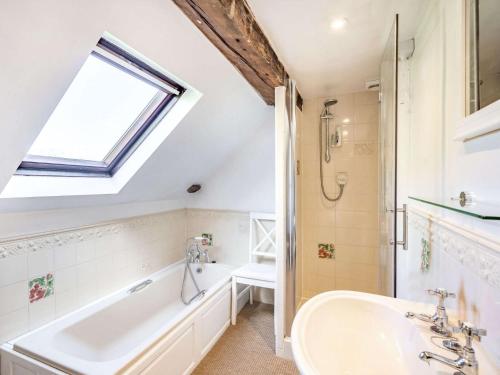 a bathroom with a sink and a tub and a window at 5 Bed in Kendal 88095 in Skelsmergh