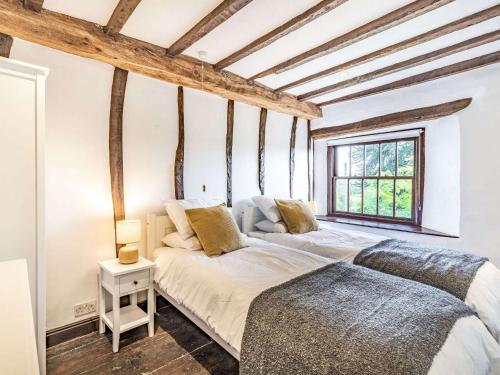 two beds in a room with wooden beams at 5 Bed in Kendal 88095 in Skelsmergh