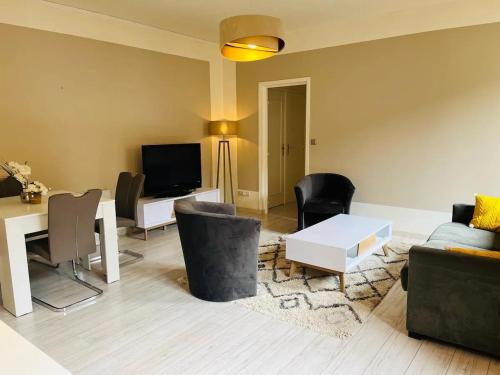 een woonkamer met een bank en een tafel bij Bienvenue l'Opale Boulogne in Boulogne-sur-Mer