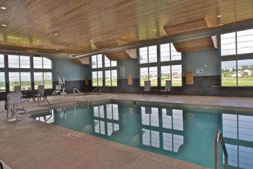 a swimming pool in a building with windows at Grandstay Hotel & Suites Mount Horeb - Madison in Mount Horeb