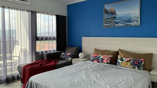 1 dormitorio con cama y pared azul en HuaHin DusitD2 Residences, apartments near beach, en Hua Hin