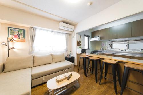 a living room with a couch and a kitchen at nestay apartment tokyo akihabara in Tokyo