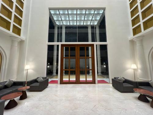 a lobby with a glass door and two couches at Pride Resort, Rajkot in Rajkot