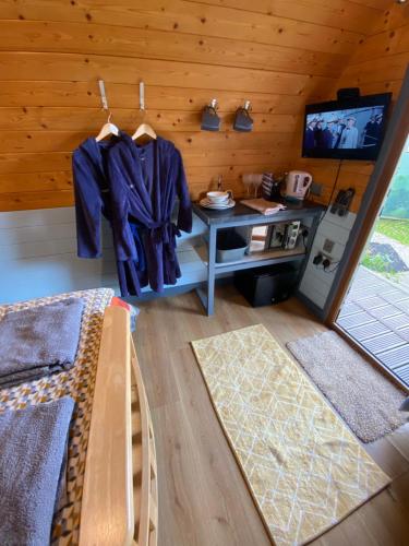 Zimmer mit einer Küche mit einem Tisch und einem TV in der Unterkunft luxury pod with hot tub in Clodock