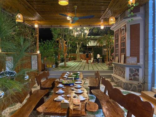 a patio with a long wooden table and chairs at Cat Ba Rustic Homestay in Cat Ba