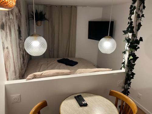 a small bed with two lights and a table at Studio Jungle-Calme rue piétonne in Limoges