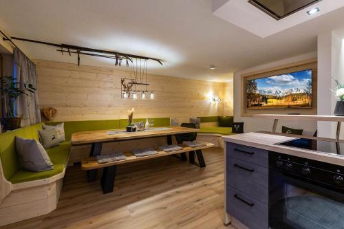 a kitchen with a wooden table and a green couch at Kummererhof in Itter