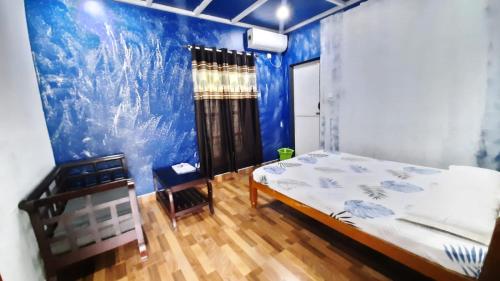 a bedroom with a bed and a blue wall at Munroe morris in Munroe Island