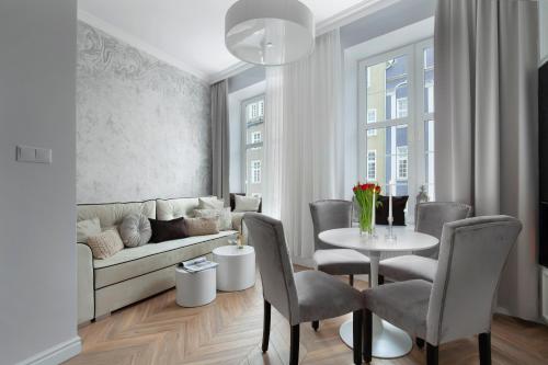 a living room with a couch and a table and chairs at Elite Apartments Piwna Prestige in Gdańsk