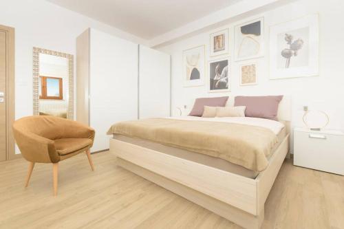 a white bedroom with a bed and a chair at Villa Rosa by IstriaLux in Loborika