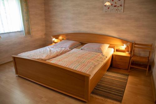 uma cama com uma cabeceira em madeira num quarto em Hof Schlüpke em Hermannsburg