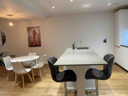 a kitchen with a table and chairs and a sink at Beautiful 3bed3bath Kensington in London