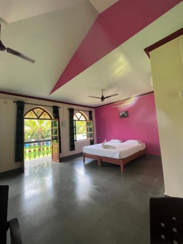 1 dormitorio con cama y pared de color rosa en Green valley jungle resort 