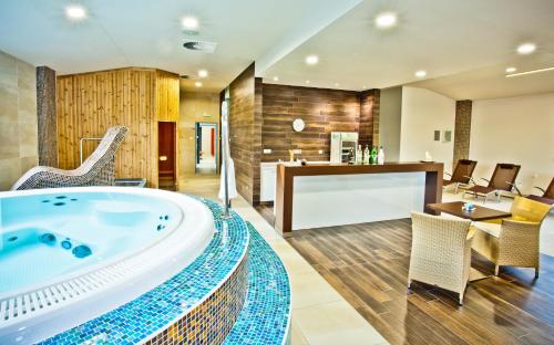 - une grande salle de bains avec baignoire au milieu d'une pièce dans l'établissement Silesia Golf Resort Kravaře, à Kravaře