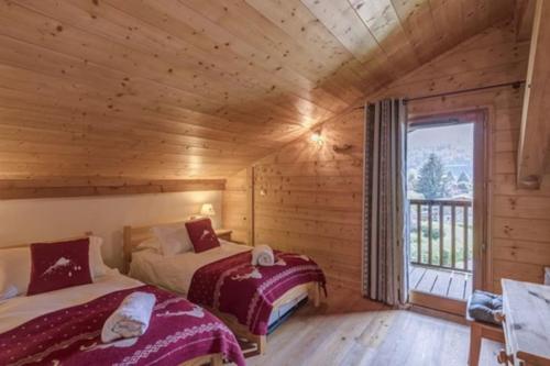 a bedroom with two beds in a log cabin at Le Chardon Argenté T4 Duplex 7 couchages - Parking in Samoëns