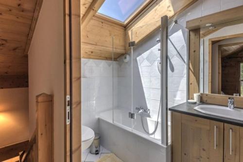 a bathroom with a sink and a toilet and a window at Le Chardon Argenté T4 Duplex 7 couchages - Parking in Samoëns