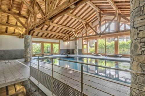 - une piscine intérieure dans une maison dotée d'un plafond en bois dans l'établissement Le Chardon Argenté T4 Duplex 4 etoiles - 7 couchages - Parking&Piscine, à Samoëns