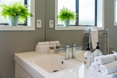 un bagno con un lavandino bianco e uno specchio di Ngaio Views - Lake Taupo Holiday Home a Taupo