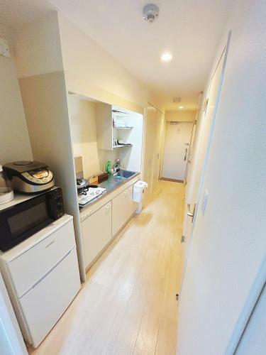 a kitchen with white cabinets and a wooden floor at Tokyo Skytree Home Skytree View Hikifune in Tokyo