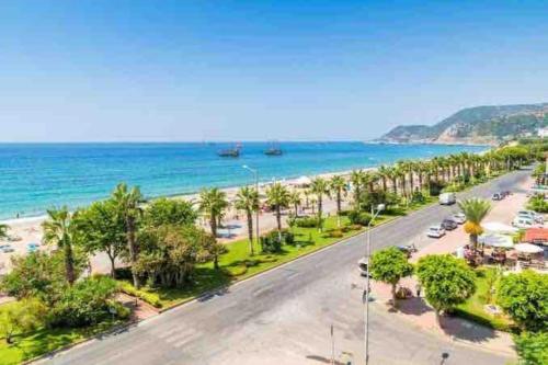 Blick auf einen Strand mit Palmen und das Meer in der Unterkunft Villa, Alanya, Antalya in Alanya