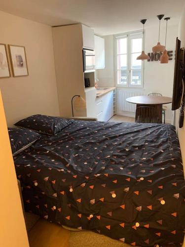 une chambre avec un lit et une cuisine avec une table dans l'établissement Superbe studio en hypercentre et rue piétonne - 3emeAdrienDubouché, à Limoges