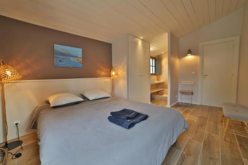 une chambre avec un grand lit avec un peignoir dessus dans l'établissement Villa du Fier, aux Portes