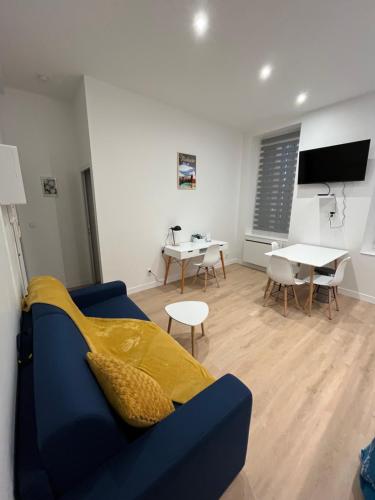 un salon avec un canapé bleu et une table dans l'établissement Spacieux T2, tout NEUF! Confort au top!, à Toulouse