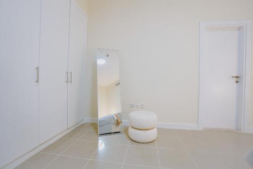 ein weißes Zimmer mit einem Stuhl und einem Spiegel in der Unterkunft Citi home 1BR New Marina Sulafa Tower in Dubai