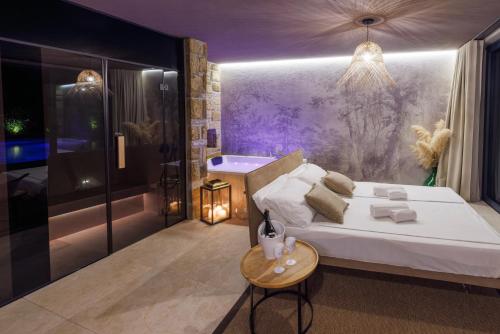 a bedroom with a large bed and a bath tub at Vila ROBIDA & SPA in Črni Kal